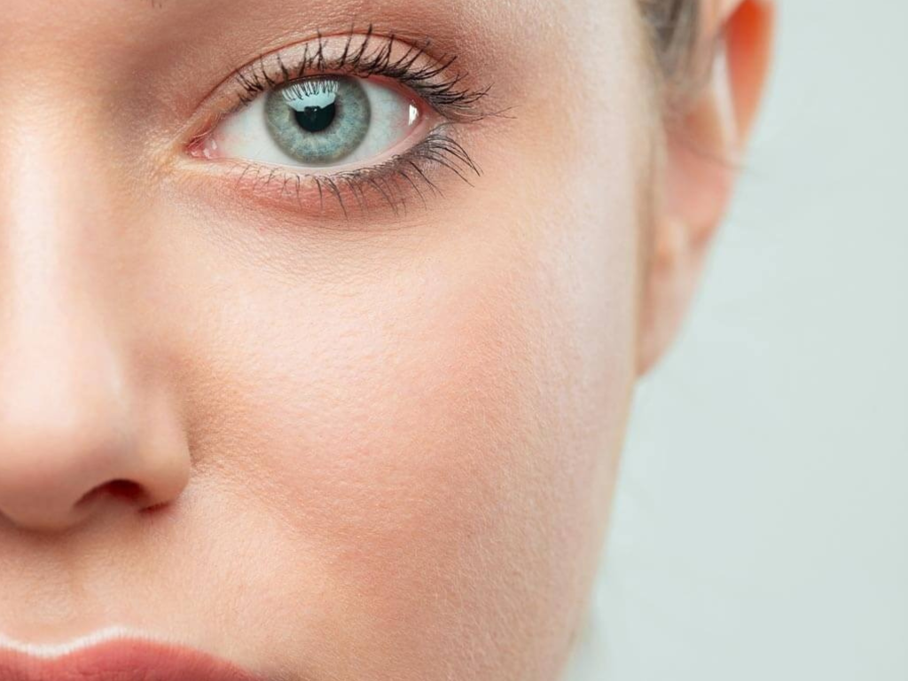 Mulher de meia-idade com expressão rejuvenescida, sorrindo com o olhar descansado e sem bolsas de gordura, representando o resultado da blefaroplastia em São Paulo na Clínica Orvia.